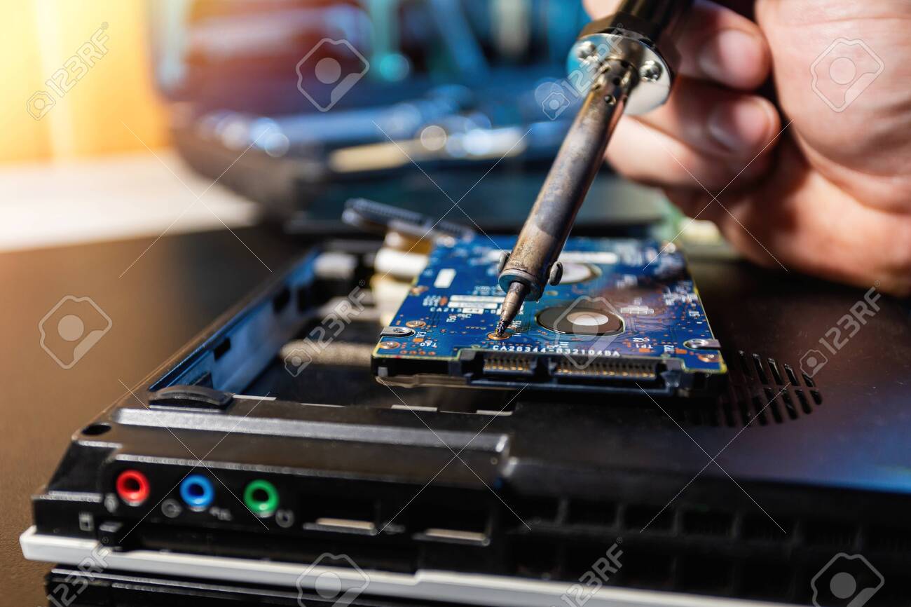 Man repairing hard drive in service center. Repairing and fixing service in lab. Electronics repair service concept. Concept of computer hardware electronic, repairing, upgrade and technology.